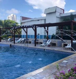 einen Pool in einem Hotel mit einem Mann im Wasser in der Unterkunft APTO ESTUIO 11 in Cartagena de Indias