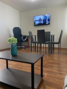 un soggiorno con sedie, tavolo e TV di Costa Verde 2 Bedrooms Apartment Miraflores a Lima