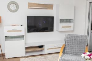 a living room with a tv and a chair at Apartment Forever in Tuzla