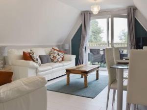 a living room with a white couch and a table at 24 Valley Lodge Holiday Cottage in Callington