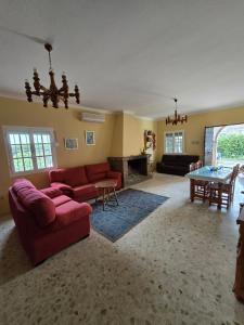 a living room with a red couch and a table at CHALET VILLA MARÍA ANTONIA in Cantillana