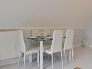 a dining room with a table and white chairs at 24 Valley Lodge Holiday Cottage in Callington