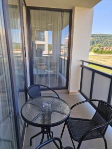 a balcony with a glass table and chairs on a balcony at VIA Apartmany in Trenčín