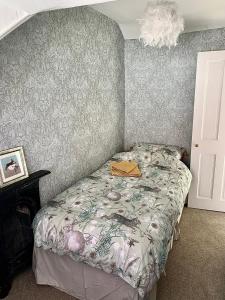 a bedroom with a bed with a floral bedspread at Bats by the Sea at Number 23 in Scarborough