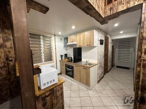 eine Küche mit Holzschränken und einer Mikrowelle in der Unterkunft La Grange in Carentan