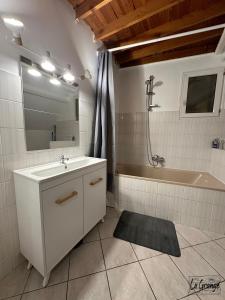 ein Badezimmer mit einem Waschbecken und einer Badewanne in der Unterkunft La Grange in Carentan