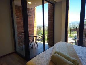 危地馬拉的住宿－Airali Apartment，一间卧室设有一张桌子和椅子的阳台