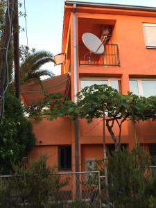 an orange building with a satellite on a balcony at Holiday home Orange family apartments in Utjeha