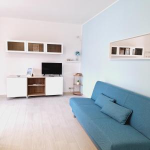 ein Wohnzimmer mit einem blauen Sofa und einem TV in der Unterkunft Conero Casa Vacanze Amelia Garden in Numana