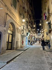 een stadsstraat 's nachts met mensen die over straat lopen bij La casetta ai Gradoni di Chiaia in Napels