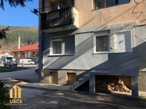a building with a pile of fire wood underneath it at Apartman Ušće in Foča