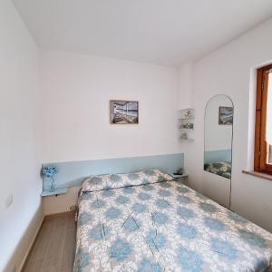 a bedroom with a bed with a quilt on it at Conero Casa Vacanze Amelia Garden in Numana