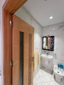 ein Bad mit einem Waschbecken und einem WC sowie einen TV in der Unterkunft Lovely family apartment in Tetouan in Tétouan