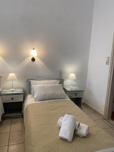 a bedroom with two towels on a bed with two tables at ARTEMIS beach studios in Kalamaki