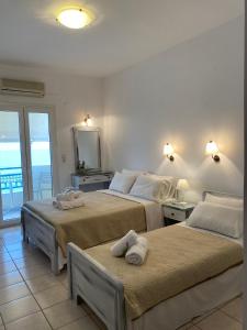 two beds in a room with a view of the ocean at ARTEMIS beach studios in Kalamaki