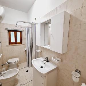bagno bianco con lavandino e servizi igienici di Conero Casa Vacanze Amelia Garden a Numana