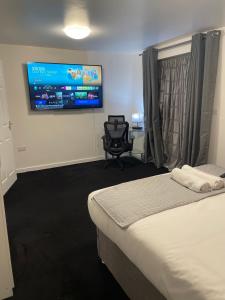 a bedroom with a bed and a chair and a tv at Home Away from Home 