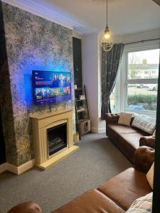 a living room with a couch and a fireplace at Cosy 3 Bed Cleethorpes retreat in Cleethorpes