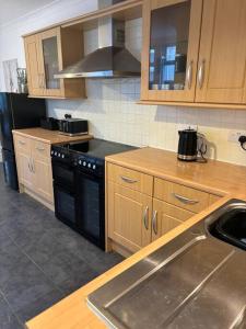 a kitchen with a sink and a stove top oven at Cosy 3 Bed Cleethorpes retreat in Cleethorpes