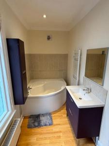 a bathroom with a large tub and a sink at Cosy 3 Bed Cleethorpes retreat in Cleethorpes