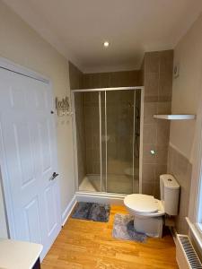 a bathroom with a toilet and a glass shower at Cosy 3 Bed Cleethorpes retreat in Cleethorpes