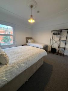 a bedroom with two beds and a window at Cosy 3 Bed Cleethorpes retreat in Cleethorpes