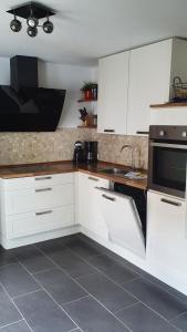 uma cozinha com armários brancos e um lavatório em Ferienhaus Ulla em Reit im Winkl