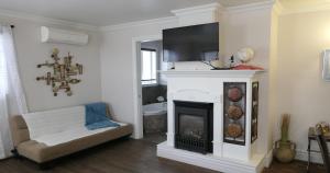 uma sala de estar com lareira e uma televisão por cima em Auberge La Daïna em Baie-Saint-Paul