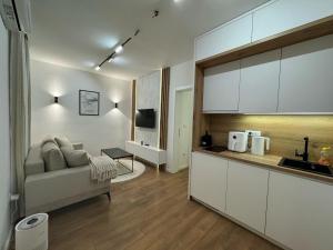 a living room with a couch and a kitchen at Mona Luxury Apartments - Free Garage Parking in Sarajevo