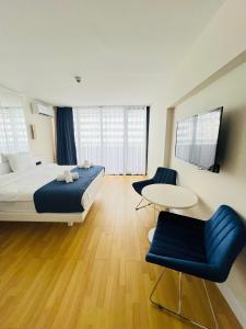 ein Hotelzimmer mit einem Bett, einem Tisch und Stühlen in der Unterkunft Elegance Sea Views Apartments in Orbi City BATUMI in Batumi
