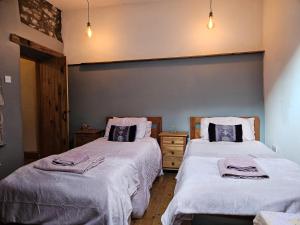 - une chambre avec 2 lits et des couvertures blanches dans l'établissement Rose Cottage - Cosy cottage in Millers Dale, à Buxton