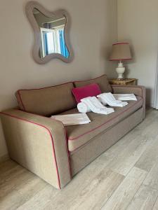 un divano in soggiorno con specchio di Les Sables Noirs & Spa- appartamento multiproprietà a Vulcano