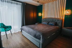 a bedroom with a bed and a green wall at Forest Peace House in Straujupes +26 photos