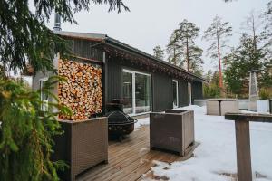 a house with a large pile of fire wood on a deck at Forest Peace House in Straujupes