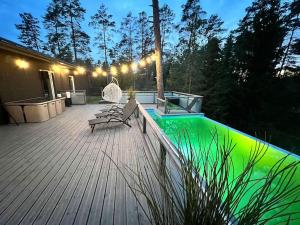 a wooden deck with a bench and lights on it at Forest Peace House in Straujupes