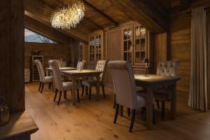 une salle à manger avec des tables et des chaises ainsi qu'un lustre dans l'établissement Chalet Royal, à Sinaia
