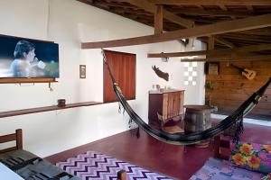 a hammock in a room with a tv at Espaço Luz in Paraty