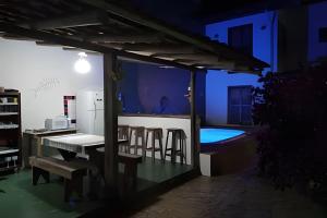 uma sala de estar com mesa e cadeiras e uma piscina em Espaço Luz em Paraty