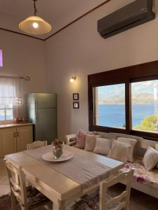 salon ze stołem i dużym oknem w obiekcie VILLA NEXT TO THE SEA!! w mieście Kalimnos