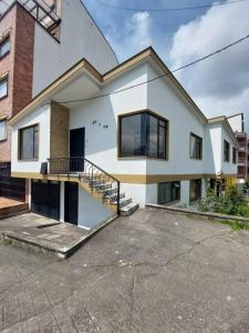 a white house with a staircase in a parking lot at Casa Palermo Manizales in Manizales