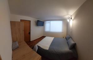 um pequeno quarto com uma cama e uma janela em Casa Palermo Manizales em Manizales