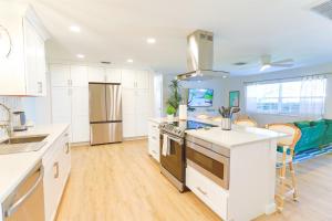 a kitchen with white cabinets and a kitchen island at Magnolia Home • Clearwater Beach • BBQ • Sunroom in Clearwater