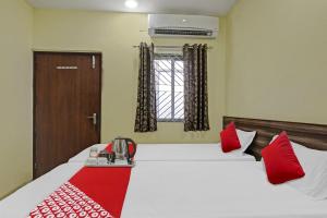 a hotel room with a bed with red pillows at OYO Flagship Hotel Maheshwari Residency in Rānchī