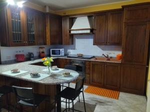 a kitchen with wooden cabinets and a table with flowers on it at Rifugio degli Dei in Monzuno