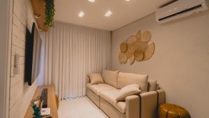 a living room with a couch in a room at Flat centro Porto de galinhas in Porto De Galinhas