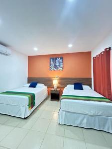 two beds in a hotel room with at Hotel Victoria in Moyogalpa