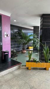 un hall avec des plantes en pot dans un bâtiment dans l'établissement Hotel Novo Plano, à Salvador