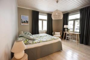 een slaapkamer met een bed, een bureau en ramen bij Villa Lotta in Hanko