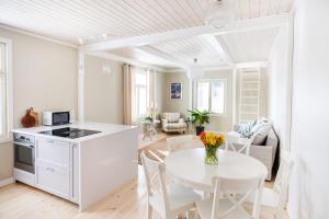 a kitchen and living room with a white table and chairs at Villa Lotta in Hanko