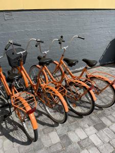 trzy pomarańczowe rowery zaparkowane obok budynku w obiekcie Villa Lotta w mieście Hanko